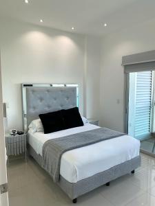 um quarto com uma cama grande e uma almofada preta em Torre EME Department em Mazatlán