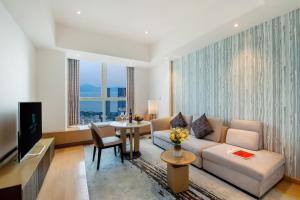 een woonkamer met een bank en een tafel bij Grade Hotel Shenzhen Shekou Sea World in Shekou