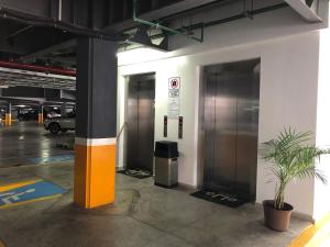 マサトランにあるTorre EME Departmentの駐車場(エレベーター2台、鉢植えの植物付)