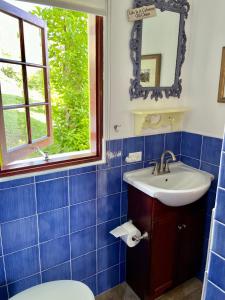 baño de azulejos azules con lavabo y ventana en Villa Lisa Bermuda en Southampton