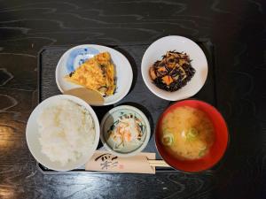 un plateau avec quatre assiettes de nourriture sur une table dans l'établissement First Inn Takamatsu, à Takamatsu