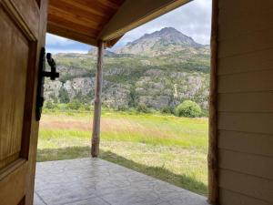 an open door to a porch with a view of a mountain at Cabaña rural límite con Argentina in Futaleufú