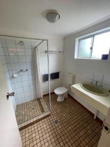a bathroom with a shower and a toilet and a sink at Pine Tree Motel in Katherine