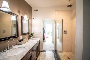 a bathroom with two sinks and a walk in shower at The Hidden Paradise Home Studio, Downtown City Views, Productions, Families & Large Groups in Baltimore