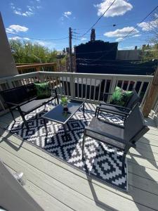 a patio with two chairs and a table on a deck at The Hidden Paradise Home Studio, Downtown City Views, Productions, Families & Large Groups in Baltimore