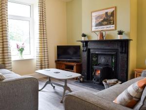 sala de estar con chimenea y TV en Three Peaks House en Horton in Ribblesdale