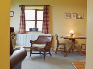 a living room with a table and a chair at The Gig House in Stonham Aspall