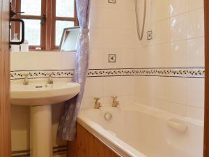 a bathroom with a sink and a bath tub and a sink at The Gig House in Stonham Aspall