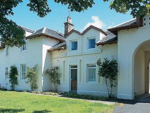 una gran casa blanca con un patio de césped en Strathisla, en Largs