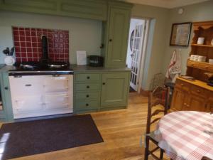 a kitchen with green cabinets and a stove at Find Me Out - Sccw in Dalmellington