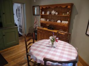 una cocina con una mesa con un jarrón de flores. en Find Me Out - Sccw, en Dalmellington