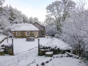 una cabaña de madera en la nieve frente a ella en Find Me Out - Sccw, en Dalmellington