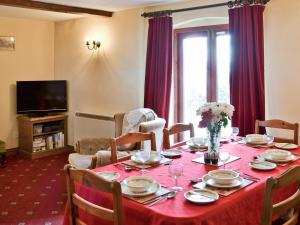 a dining room with a table with a red table cloth at Craneham Court in Buckland Brewer