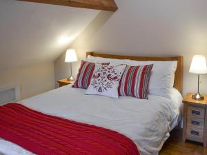 a bedroom with a white bed with two lamps at The Old Stable in Edale