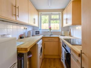 a kitchen with wooden cabinets and a counter top at Lilac Studio in Wheldrake