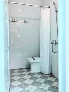 a white bathroom with a toilet and a shower at City Garden Hostel in Ninh Binh