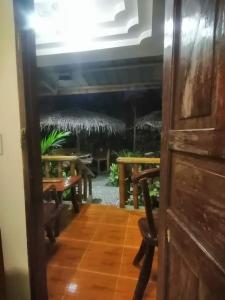 a room with tables and benches and a door at Dhadas place in San Vicente