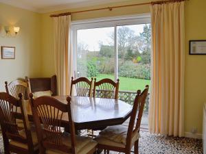 a dining room with a table and chairs and a window at Goonlaze in St Austell