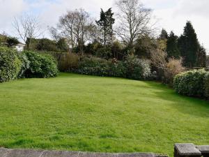 a large yard with a green lawn and bushes at Goonlaze in St Austell