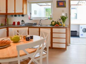 cocina con mesa, sillas y fregadero en Cobis Cape Cottage, en St Just