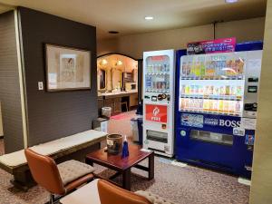 une chambre avec une machine à soda et une table dans l'établissement First Inn Takamatsu, à Takamatsu