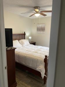een slaapkamer met een bed en een plafondventilator bij Beyond Comfort in Hinesville