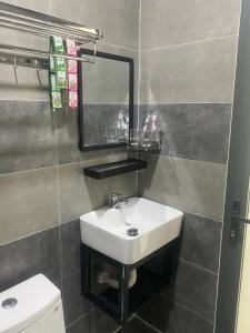 a bathroom with a sink and a mirror and a toilet at Hotel Hòa Bình in Binh Chau