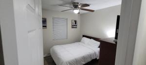 een slaapkamer met een bed en een plafondventilator bij Beyond Comfort in Hinesville