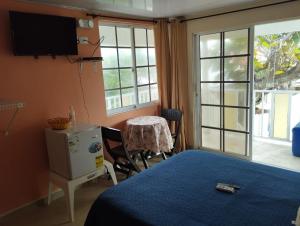 a bedroom with a bed and a table and a window at South Beauty in San Andrés