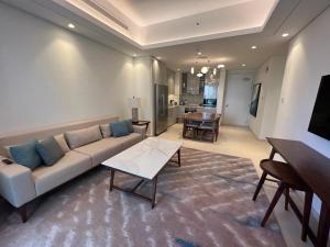 een woonkamer met een bank en een tafel bij The Address Residence Fujairah in Fujairah