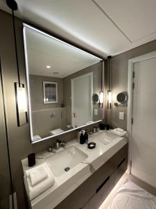 a bathroom with a large mirror and a sink at The Address Residence Fujairah in Fujairah