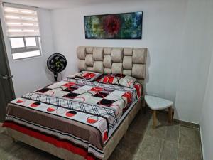 1 dormitorio con 1 cama y una pintura en la pared en Aparta Estudio 2 Camas - Parqueadero para Moto - Ibagué - Ciprés, en Ibagué