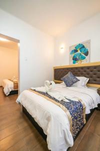 sypialnia z dużym łóżkiem z białą pościelą w obiekcie Manantial Hostal No.004 w mieście Lima