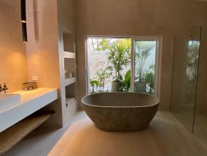 a large bath tub in a bathroom with a window at Tallowwood House Luxury Bed & Breakfast in Port Macquarie