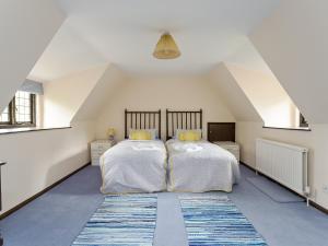 een slaapkamer met 2 bedden op een zolder bij Old High Hall in Cowlinge