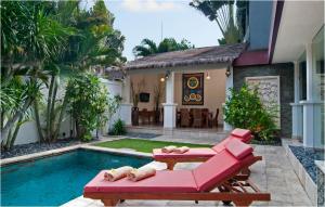 a house with a swimming pool with a red couch and a swimming pool at 6BR Villa Sensel - Minggu Villas Seminyak in Seminyak