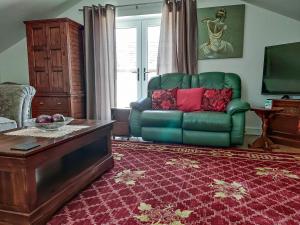 a living room with a green couch and a table at Kingford Lodge in High Bickington