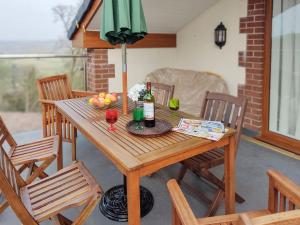 a wooden table with two wine bottles and a bowl of fruit at Kingford Lodge in High Bickington
