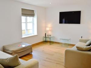 ein Wohnzimmer mit einem Sofa und einem TV in der Unterkunft Gylly Beach View - Tor in Falmouth