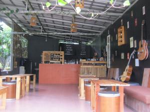 a restaurant with wooden tables and guitars on the wall at Aqilakost Gadog Puncak Bogor in Bogor