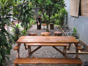 a wooden picnic table and benches in a garden at Aqilakost n Cafe Gadog Puncak in Bogor