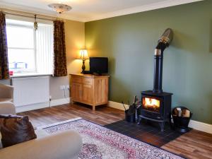 a living room with a wood stove in a room at The Parlour - SNNM in Carnwath