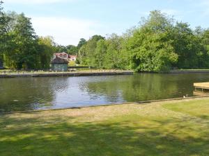 a body of water with a house in the background at The Wherry in Wroxham