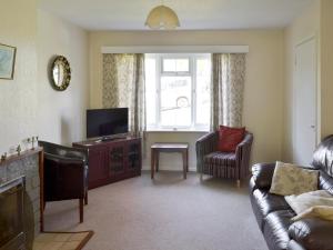 a living room with a couch and a tv at Dene Corner in Stokenham