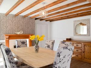 Broxa的住宿－Whisperdale Barn，一间带木桌和椅子的用餐室
