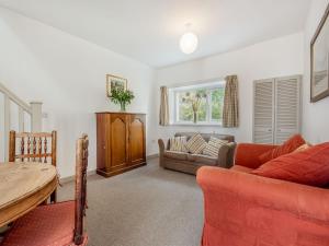 a living room with a couch and a table at 2 Cromwells Cottage-uk40929 in Pembroke