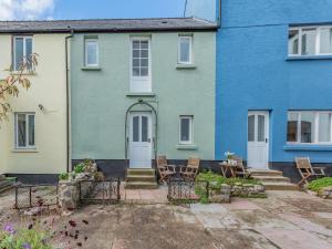 a blue and white house with a patio at 2 Cromwells Cottage-uk40929 in Pembroke