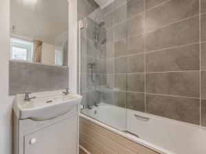 a bathroom with a sink and a shower and a tub at 2 Cromwells Cottage-uk40929 in Pembroke