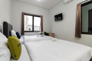 Postel nebo postele na pokoji v ubytování Urbanview Hotel Pasar Baru Jakarta by RedDoorz