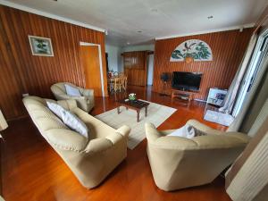 a living room with two couches and a television at Loverly 3 Bedroom rental pool outdoor area in Suva